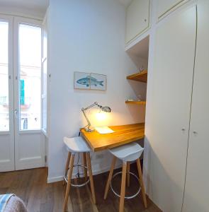 a desk in a room with a lamp and two stools at B&B 106 Maison de Charme in Mola di Bari