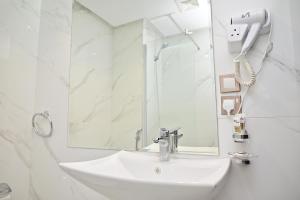 a white bathroom with a sink and a mirror at فندق أورنسيس الحرم in Mecca +16 photos