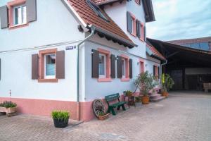 um edifício com um banco verde à sua frente em SCHULTE Appartements & MEHR em Meißenheim