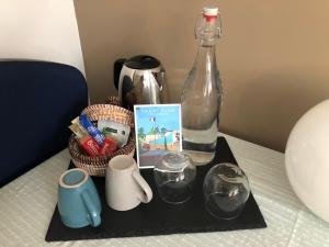 bandeja con una botella y otros artículos sobre una mesa en Chambre et Petit-déjeuner à Collonges au Mont d'Or en Collonges-au-Mont-dʼOr