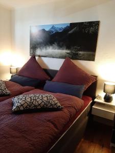 a bed with two pillows and a painting on the wall at Ferienwohnungen im Griachalgarten - Chiemgau Karte in Inzell