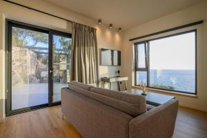 salon z kanapą i dużym oknem w obiekcie Mani Suites luxury seaside accommodation w mieście Ajos Nikolaos