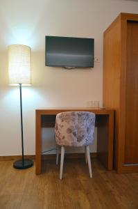 a room with a desk with a chair and a television at Quinta do Limite - Agroturismo in Covilhã