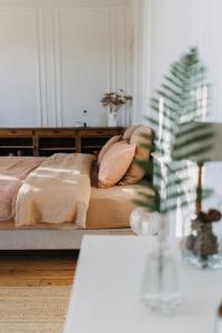 um quarto com uma cama com almofadas e uma mesa em La Maison Pelloquin em Bernières-sur-Mer