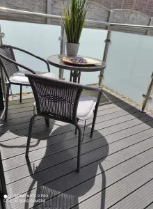 two chairs and a table on a deck at Maximus Apartamenty in Ustka