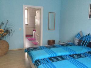 um quarto azul com uma cama e um corredor em Ferienwohnung Burgblick em Plaue