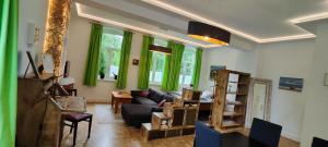 a living room with green curtains and a couch at Modernes Wohnen am See in Schwerin