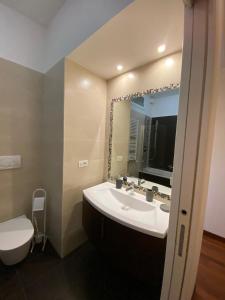 a bathroom with a sink and a toilet and a mirror at Diamond Apartment in Rome