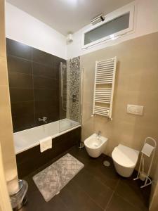 a bathroom with a toilet and a tub and a sink at Diamond Apartment in Rome