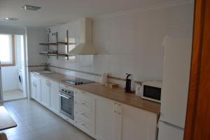 a kitchen with white cabinets and a counter top at Touristhome Frei Luis in Sarria