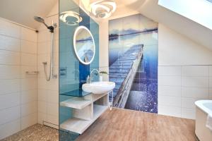 a bathroom with a sink and a shower and a staircase at Hotel Am Steendamm in Oyten