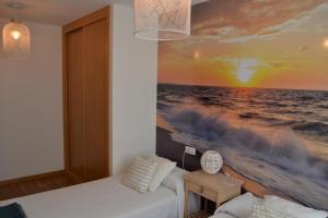 a bedroom with a painting of the ocean at Touristhome Frei Luis in Sarria
