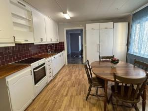 a kitchen with a wooden table and a dining room at 3BDR close to nature a beautiful home LAKE nearby in Uppsala