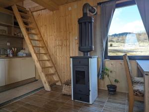 a wood stove in a kitchen with a staircase at AA Pine vikendica za izdavanje u srcu Zapadne Srbije in Nova Varoš