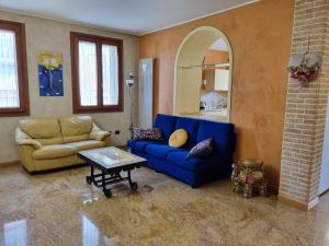 a living room with a blue couch and a table at Consuelo House in Arzergrande