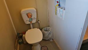 a small bathroom with a toilet and a refrigerator at Heleni Jessop's Fatahega in Alofi