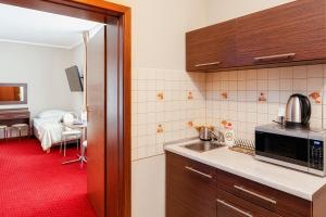 a kitchen with a sink and a room with a bed at Villa Gronie Ski & Bike in Szczyrk