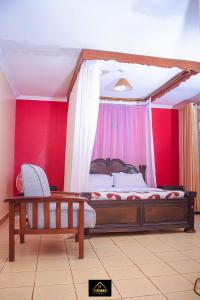 Schlafzimmer mit einem großen Bett mit roten Wänden in der Unterkunft jirime hotel &resort in Marsabit