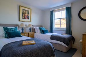 a bedroom with two beds and a window at Seabiscuit in Lymington