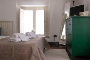 sypialnia z zieloną komodą i łóżkiem z ręcznikami w obiekcie Civico 18 w Katanii
