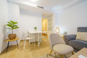 ein Wohnzimmer mit einem Sofa und einem Tisch in der Unterkunft HomeHolidaysRentals Zen - Costa Barcelona in Pineda de Mar