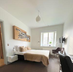 a bedroom with a bed and a chair and a window at Bernstorff Castle Hotel in Gentofte