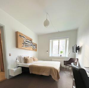 1 dormitorio con 1 cama, 1 silla y 1 ventana en Bernstorff Castle Hotel, en Gentofte