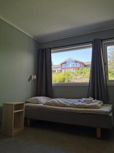 een slaapkamer met een bed en een groot raam bij BiG Event AS in Grimstad