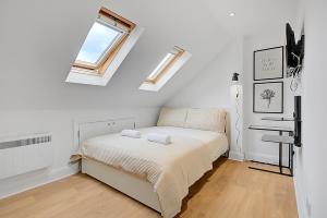 ヘンドンにあるQuality Apartments Close to Tubeのベッドとタオル2枚のある寝室