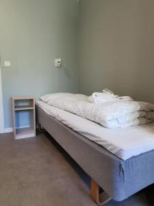 een bed in een kamer met een kleine tafel bij BiG Event AS in Grimstad