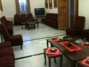 a waiting room with chairs and tables and a tv at St Thomas Home's Guesthouse - Jerusalem in Jerusalem