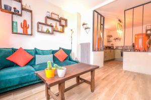 a living room with a blue couch and a table at Les Valéricaines Appartement Vieille Ville Saint Valery sur Somme in Saint-Valery-sur-Somme