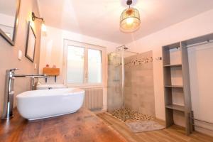 a bathroom with a large white tub and a shower at Les Valéricaines Appartement Vieille Ville Saint Valery sur Somme in Saint-Valery-sur-Somme