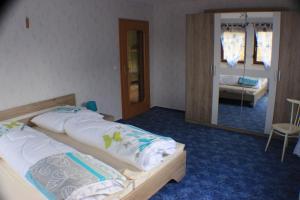 1 dormitorio con 2 camas y espejo en Ferienwohnung Rochlitzer Berg Blick, 