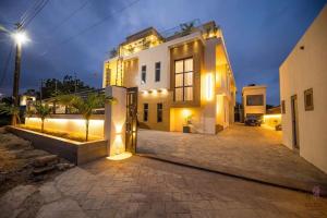 una casa con una entrada delante de ella por la noche en ELEGANT DUPLEX @ Rosedale Apartments, en Accra
