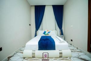 una cama grande en una habitación con ventana en ELEGANT DUPLEX @ Rosedale Apartments, en Accra