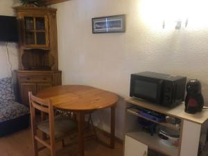 a room with a small table and a tv at DUPLEX ALCAZABA con parking gratuito, 2 dormitorios , 5pax in Sierra Nevada