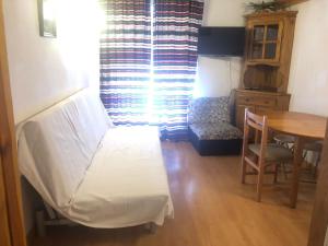 a bed in a room with a table and a window at DUPLEX ALCAZABA con parking gratuito, 2 dormitorios , 5pax in Sierra Nevada