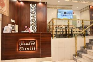 a woman sitting at a counter in a cosmetics store at فندق أورنسيس الحرم in Mecca