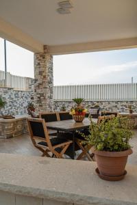 un patio con mesa, sillas y plantas en Villa Panorama sul Mare, en Balestrate