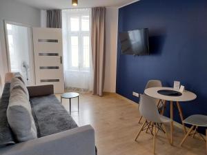 a living room with a couch and a table at Apartamenty - Studio Gliwice II in Gliwice