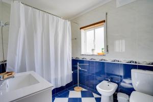 a blue and white bathroom with a toilet and a sink at Peniche Sun & Surf Apartment in Peniche +25 photos