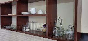 a wooden shelf with glass bottles and dishes on it at Orchard Residence Arusha in Arusha