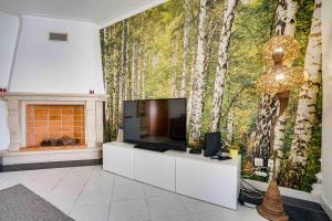 a living room with a tv and a tree mural at Peniche Sun & Surf Apartment in Peniche