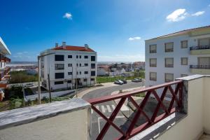balcón con vistas a la calle y a los edificios en Peniche Sun & Surf Apartment en Peniche