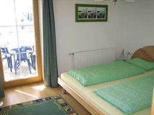 a bedroom with a bed and a window with a patio at Apart Sonneck in Arzl im Pitztal