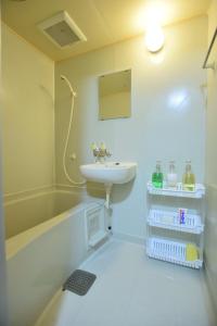 uma casa de banho com um lavatório e uma banheira em Matsuyamachi Shimanouchi Building - Vacation STAY 14368 em Osaka