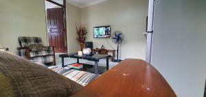 ein Wohnzimmer mit einem Sofa und einem Tisch in der Unterkunft Orchard Residence Arusha in Arusha