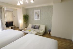 uma sala de estar com duas camas e um sofá em Matsuyamachi Shimanouchi Building - Vacation STAY 14368 em Osaka