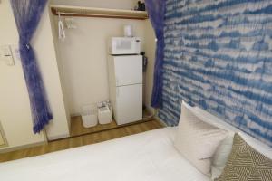 um quarto com uma cama e um micro-ondas em cima em Matsuyamachi Shimanouchi Building - Vacation STAY 14368 em Osaka